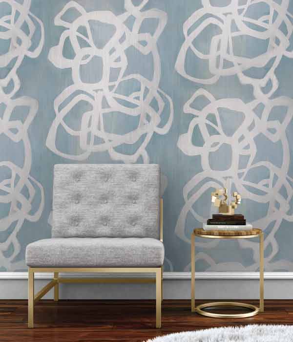 chair and lamp in front of wall with large open pattern wall covering