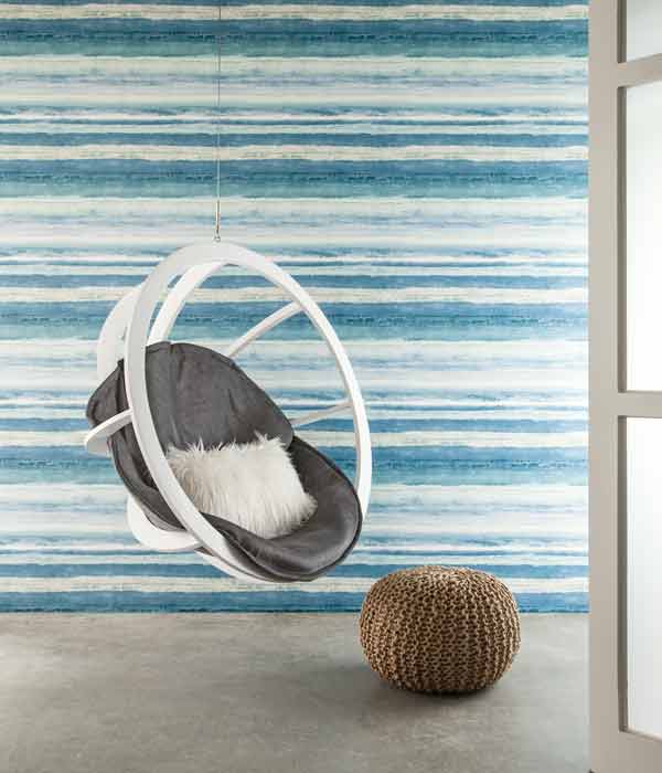 swinging chair in front of a wall with blue horizontal stripes wallpaper