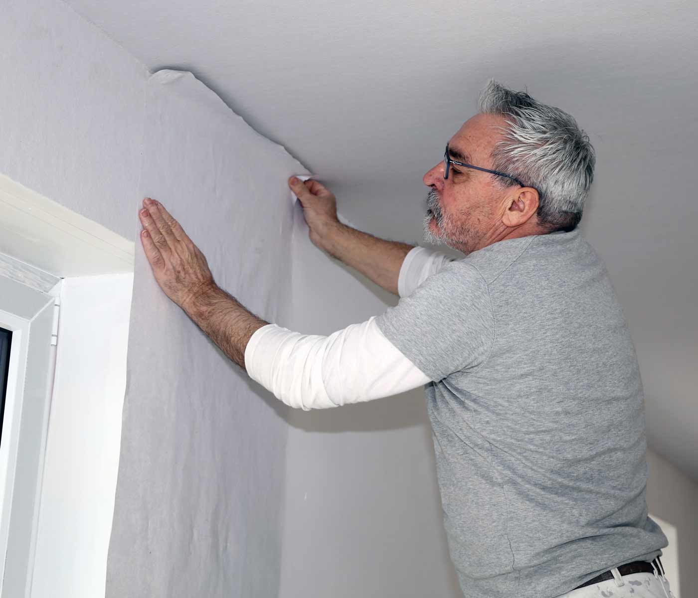 man matching pattern while installing wallpaper